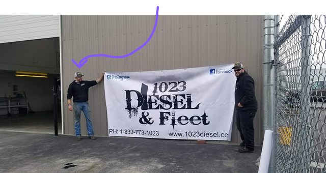 Dustin and Robert holding up the company banner at the first opening of the new 1023 diesel location